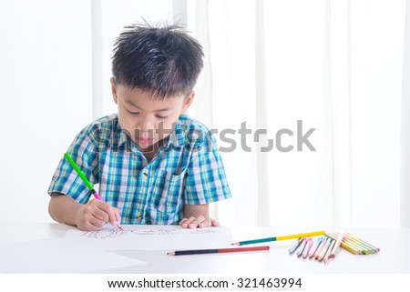 Portrait of Asian boy  is drawing using color pencil on white background