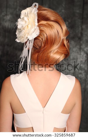 fashion photo of elegant and sexy red woman in white dress,beautiful hairstyle with decorative rose in her hair posing at studio