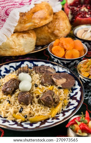 Traditional arabian gourmet. Pilaf with large pieces of fried halal meat, pieces of horse meat sausage, spicy rice, barberry, yellow carrots and quail eggs.