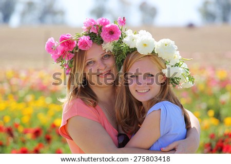 Mother and teenage daughter talking  in a flowering field