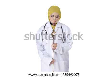 A female doctor with stethoscope holding a dead flower as a symbol of lose hope in life with isolated white background