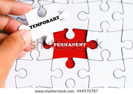 'PERMANENT' word on missing puzzle with a hand hold a piece of 'TEMPORARY' word puzzle want to complete it - business and finance concept Foto d'archivio © 