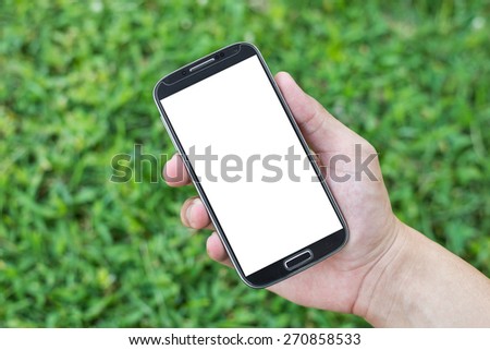 Hand holding smart phone (Mobile Phone) on grass background