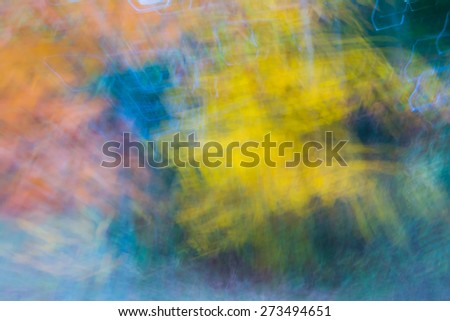 Abstract motion blur of fall colored trees.  Yellow and orange are blurred for a blur background affect.