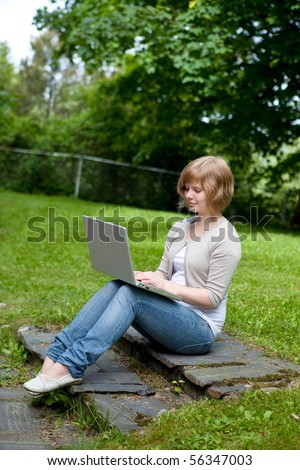 Young female working on a laptop in an outdoor setting