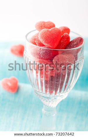 Heart shape candy in a glass for Valentine\'s day on a light blue background