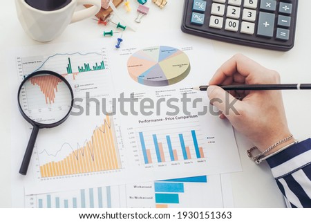Business analyst working - hand with pen, calculator, coffee, magnifier, worksheet and graph Imagine de stoc © 