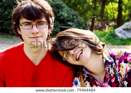 Closeup of a smiling young woman hugging a man from behind against