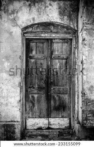 A very old door of a building in black and white vintage tones.
