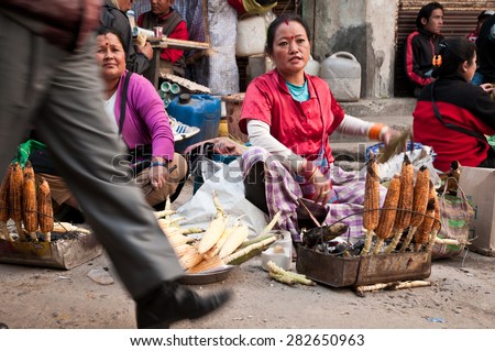 DARJEELING, INDIA - APRIL 12: Nepali women sell hot roasted corn over the street side on April 12, 2014 in Darjeeling, West Bengal, India. Hot roasted corn is a popular street food in the hills.