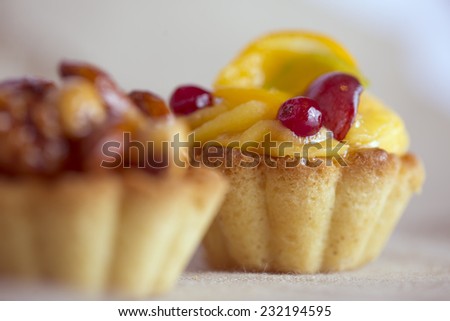 Fruit cake and defocused nuts cake in front