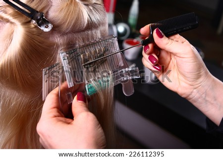 woman\'s head in progress of making a hair set on white background with hairdresser hands closeup
