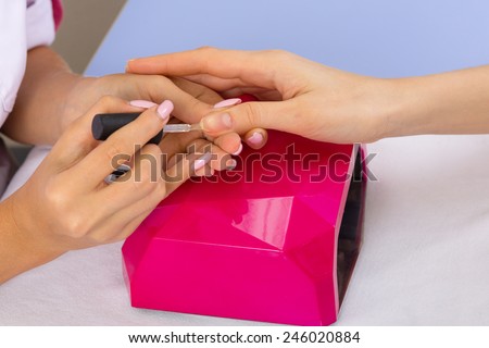 step of manicure process: nail covering with nail gel polish