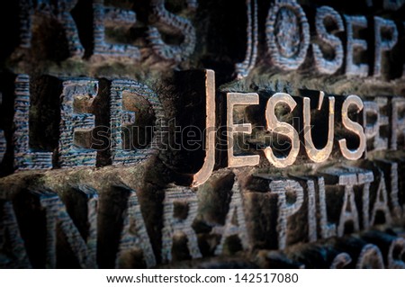 Text written with golden letters. Name Jesus standing out among other names of saints. Beautiful old wall of church in dark colours. Holy and religious place. Famous destination for tourists.
