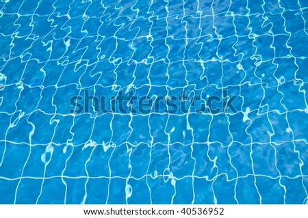 pool bottom visible through clear blue and transparent water with ripples