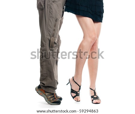 male and sexy female lower body parts isolated on white background. Man on his tiptoes trying to kiss girl