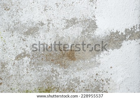 Grunge wall texture background. Paint cracking off dark wall with rust underneath.