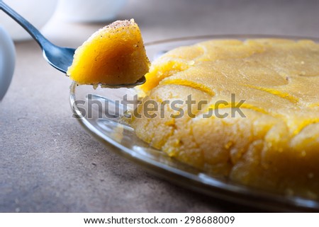 an Iranian sweetmeat made by sugar and flour and saffron - a piece picked by spoon