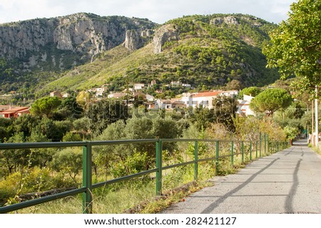 The landscape of southern Italy. Mountain, road, green trees.