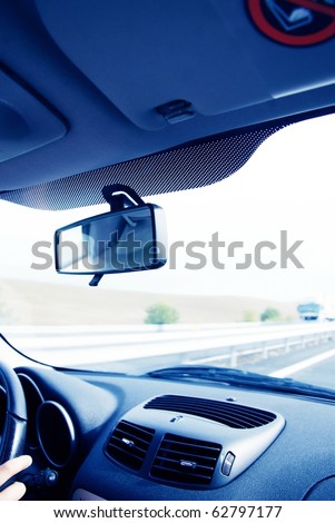 Driver in car holding steering wheel. Blurred road and sky-3