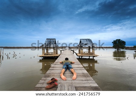 The man squat on bridge for see view ,Thailand