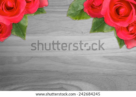 Red roses on wood background.