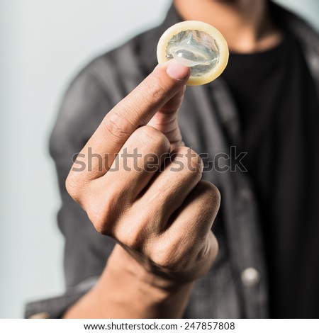 Hand of men with condom. Safe sex concept.