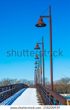 Snow on a bridge with a row of lights