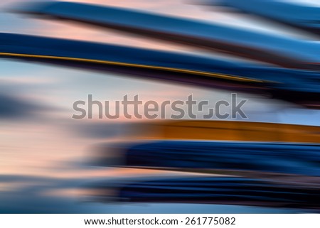 Blurred kayak boats against a blurred sunset sky