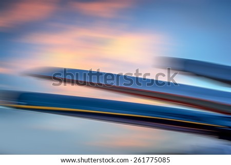 Blurred kayak boats against a blurred sunset sky