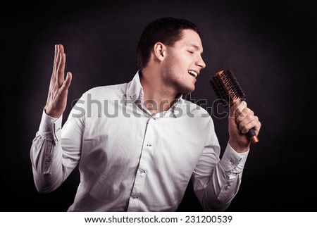 a young black man with a funny shows singer comb hair in his hand