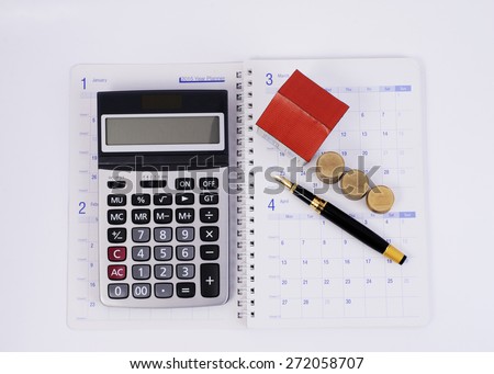 Calculator and Fountain pen and coins stack and paper house on calendar book pages for Home loans concept