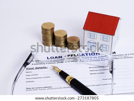 Mortgage loans concept with Fountain pen and eyeglasses and paper house and coins stack on Loan Application form