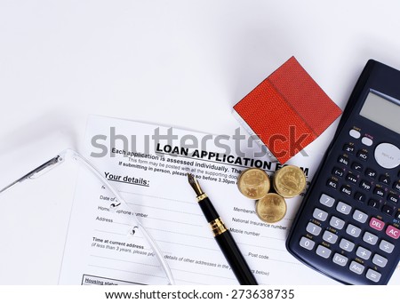 Home loans concept with fountain pen and loan application form and coins stack and paper house and calculator and eyeglasses