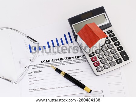 Business fountain pen and paper house on calculator and eyeglasses on loan application form for mortgage loans concept