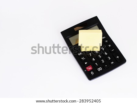 Mortgage loans concept with top views of yellow paper house and black calculator on white background