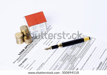 House paper and coins stack with business fountain pen on loan application for mortgage loan concept