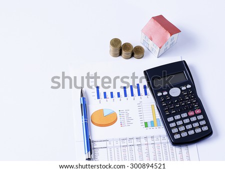 Mortgage loans concept with House paper and coins stack with pen and calculator on business chart