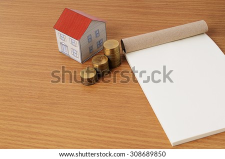 Paper house with coins stack and notepad for Mortgage loans concept