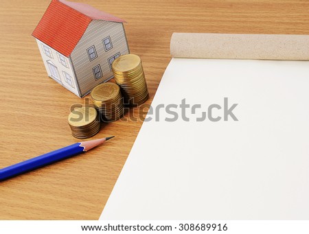 Coins stack with blue pencil and paper house and notepaad