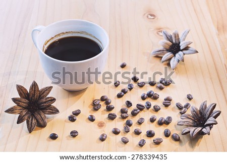 Coffee cup and Coffee beans on a wooden table in vintage tone color style, selective focus  (detailed close-up shot)