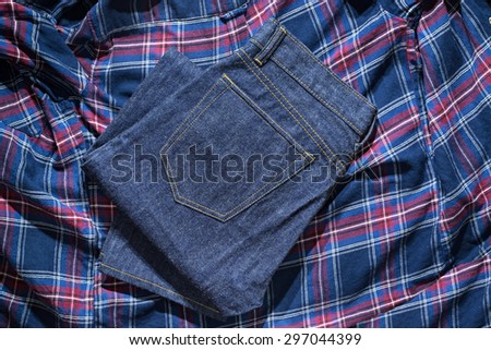 Blue Jeans Denim, 100% Cotton Un sanforized Denim Red Selvage Jeans on Plaid Shirt background, selective focus (detailed close-up shot)