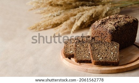 A loaf of fresh rye bread and three slices on a board. Left empty empty space Foto d'archivio © 