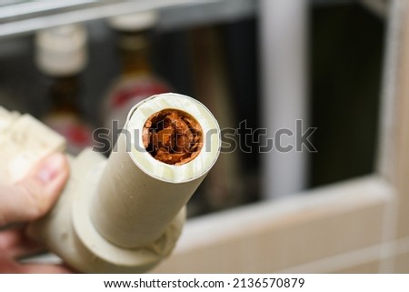 Plumbing polypropylene pipe clogged with dirt and scale in the hand. The concept of replacing water pipes due to poor quality water supply. Selective focus on the pipe section. Stock foto © 