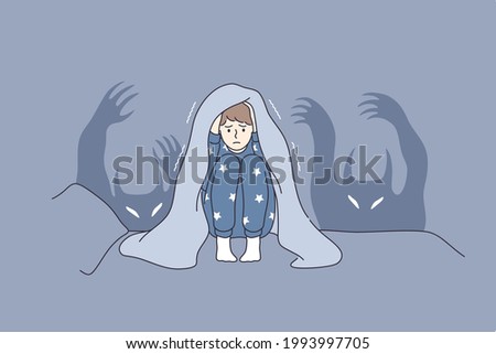 Children nightmares and fears concept. Afraid kid cartoon character sitting in bed covering head with blanket afraid of ghosts and hiding in bed vector illustration 
