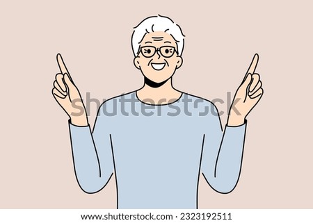 Eldery man came up with idea and points fingers up with smile to draw attention to your ad. Gray-haired pensioner in glasses recommends paying attention to good offer or cool idea.