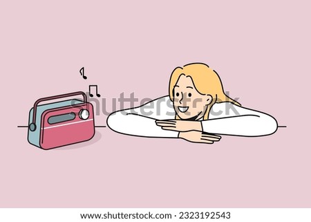 Woman is listening to radio using vintage fm receiver and enjoying analog sound of music. Hipster girl put head on table and looks with smile at retro radio device for playing compositions