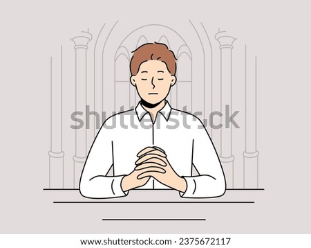 Man praying sitting on bench in temple seeking spiritual support in catholic and christian religion. Guy closes eyes and praying standing in orthodox cathedral and needs help of lord
