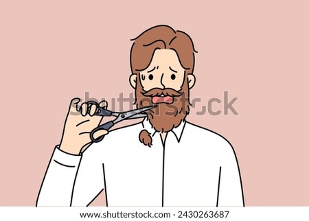 Man cuts off own beard with scissors because of appearance requirements at new job. Adult depressed guy is stressed due to need to get rid of beard or lack of money to go to barbershop. 
