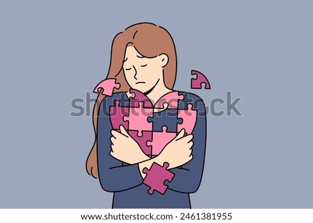 Sad woman holds disintegrating heart, symbolizing restoration of psyche after breaking up with guy. Girl with heart from puzzle, for concept of oncological diseases and cardio organ cancer